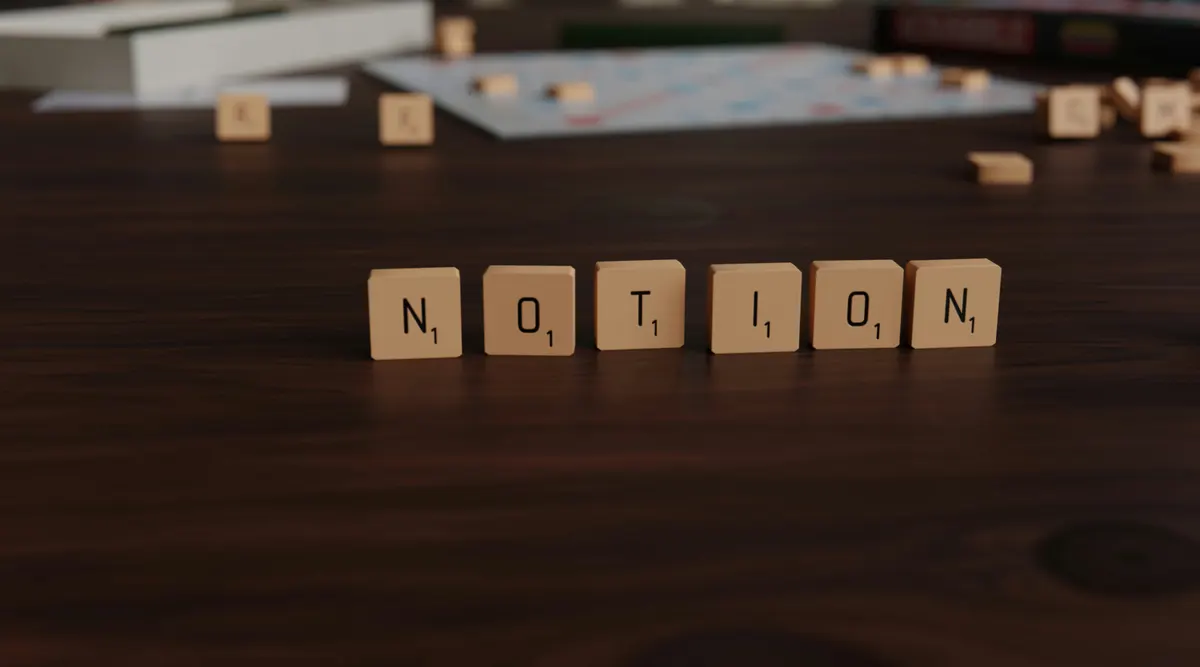 Scrabble tiles spelling out Notion on a wooden table surface