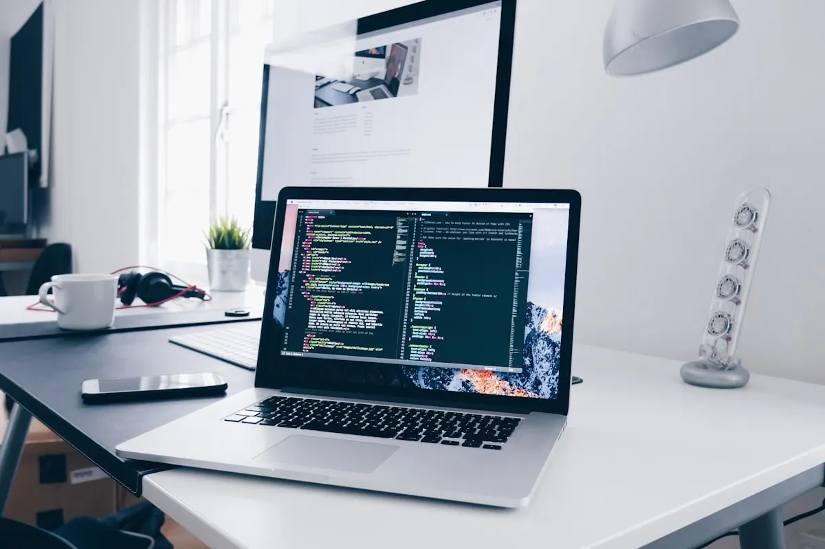 Clean desk setup with coding on laptop screen